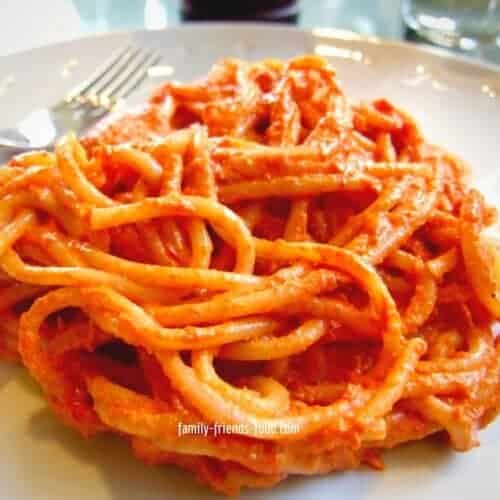 A plateful of spaghetti with red pepper sauce.