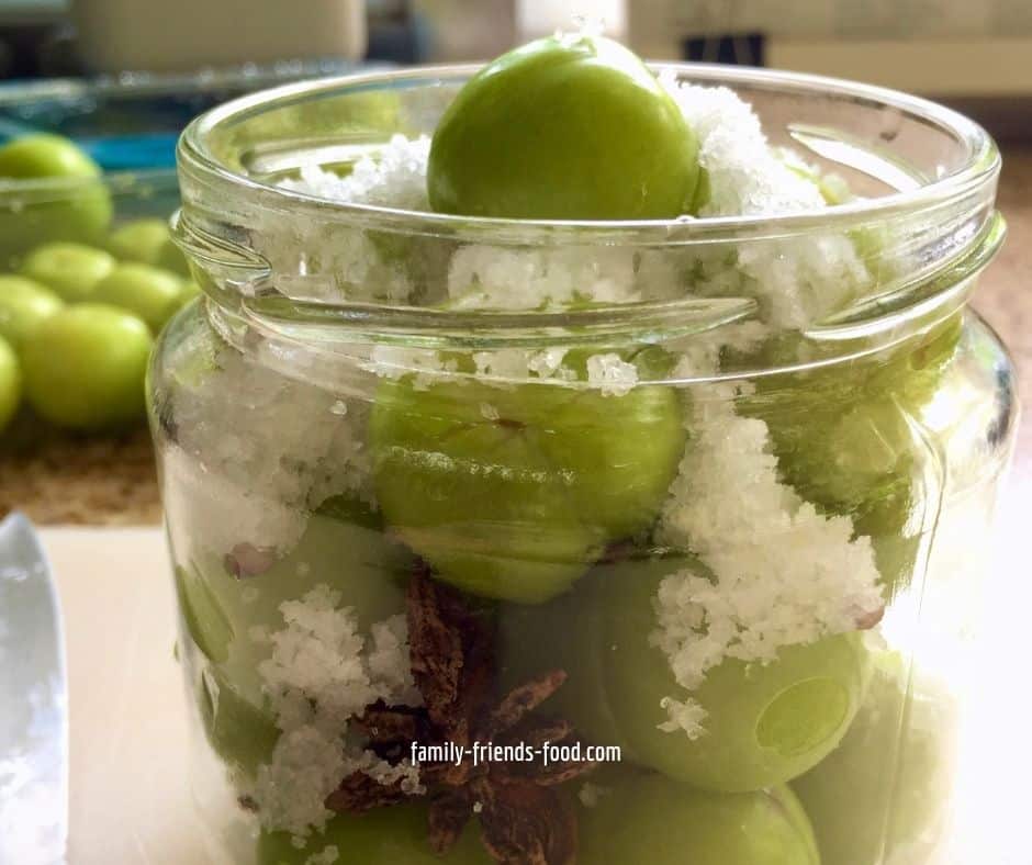 jar of green plums and star anise packed in salt.