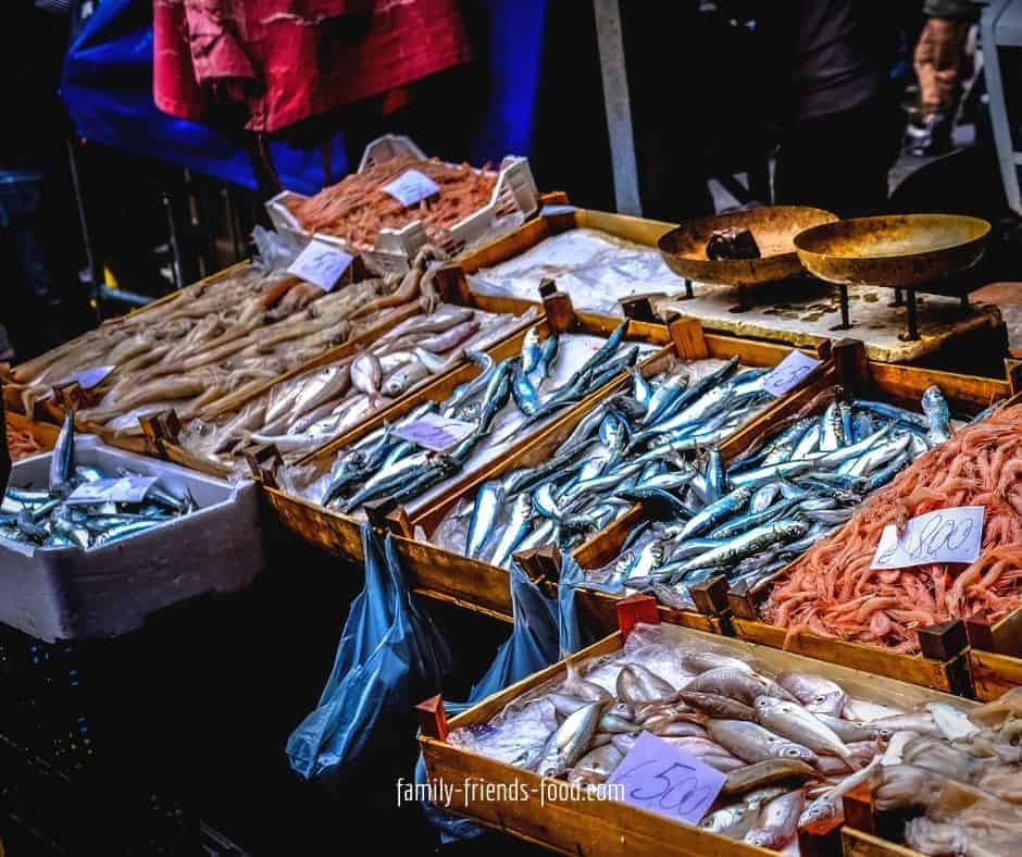 A fish stall with boxes of different varieties of fish.
