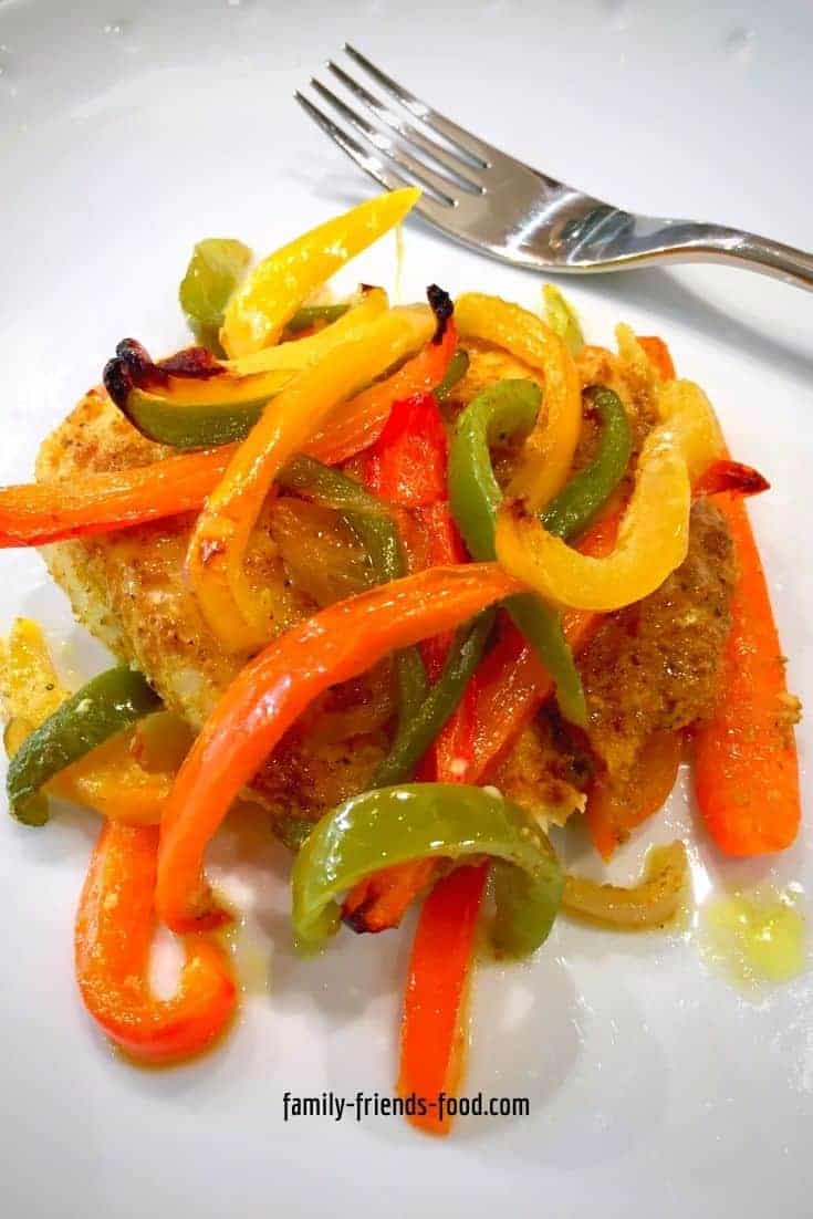 A serving of baked fish with hawaij spices and sweet peppers, on a plate.