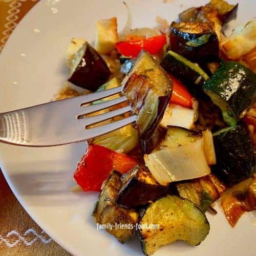 Mediterranean vegetables and halloumi on a plate with fork.