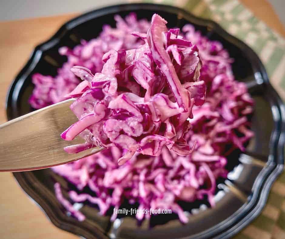 Close up of a forkful of red cabbage salad.
