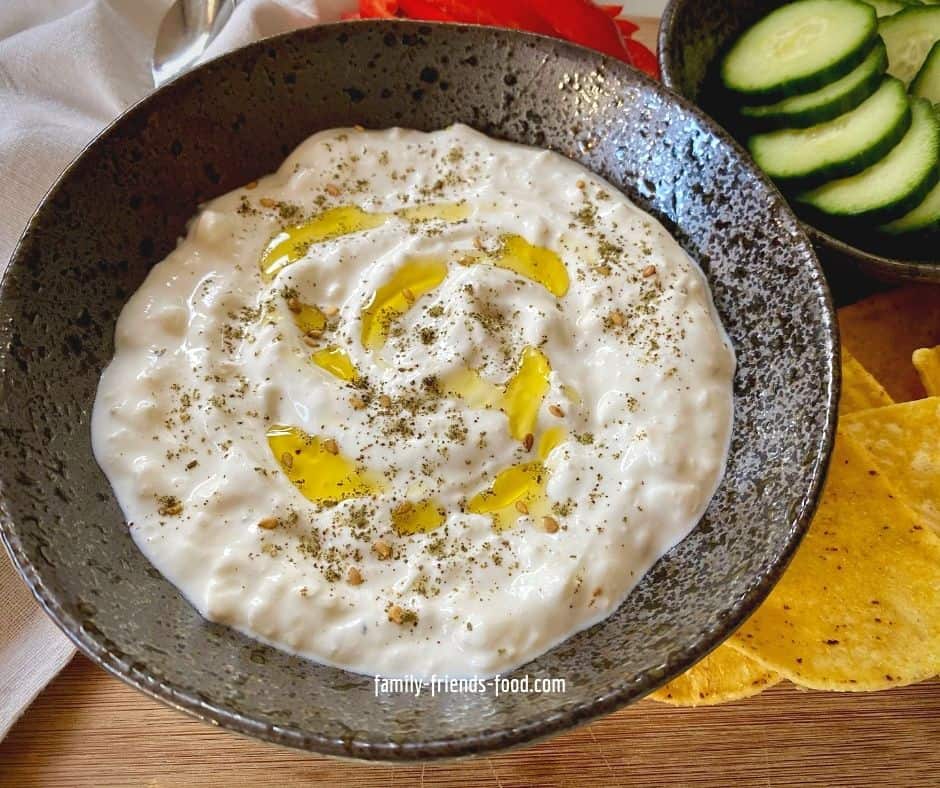 Bowl of feta cheese dip with a drizzle of olive oil and a sprinkle of za'atar.