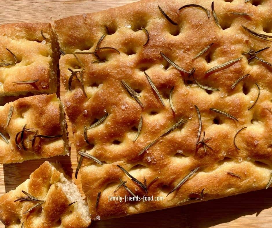 Focaccia on a wooden board, seen from overhead.