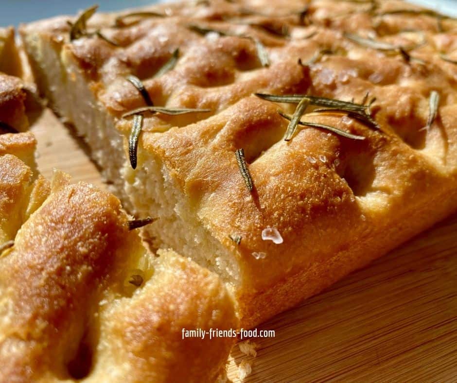 Focaccia on a wooden board, seen from the side.