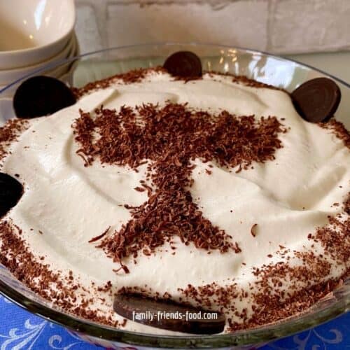 Chanukah trifle ready to serve, in front of a stack of white dessert bowls.