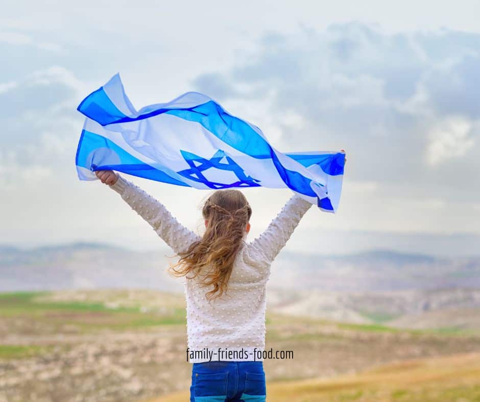 Girl holding an Israeli flag above her head.